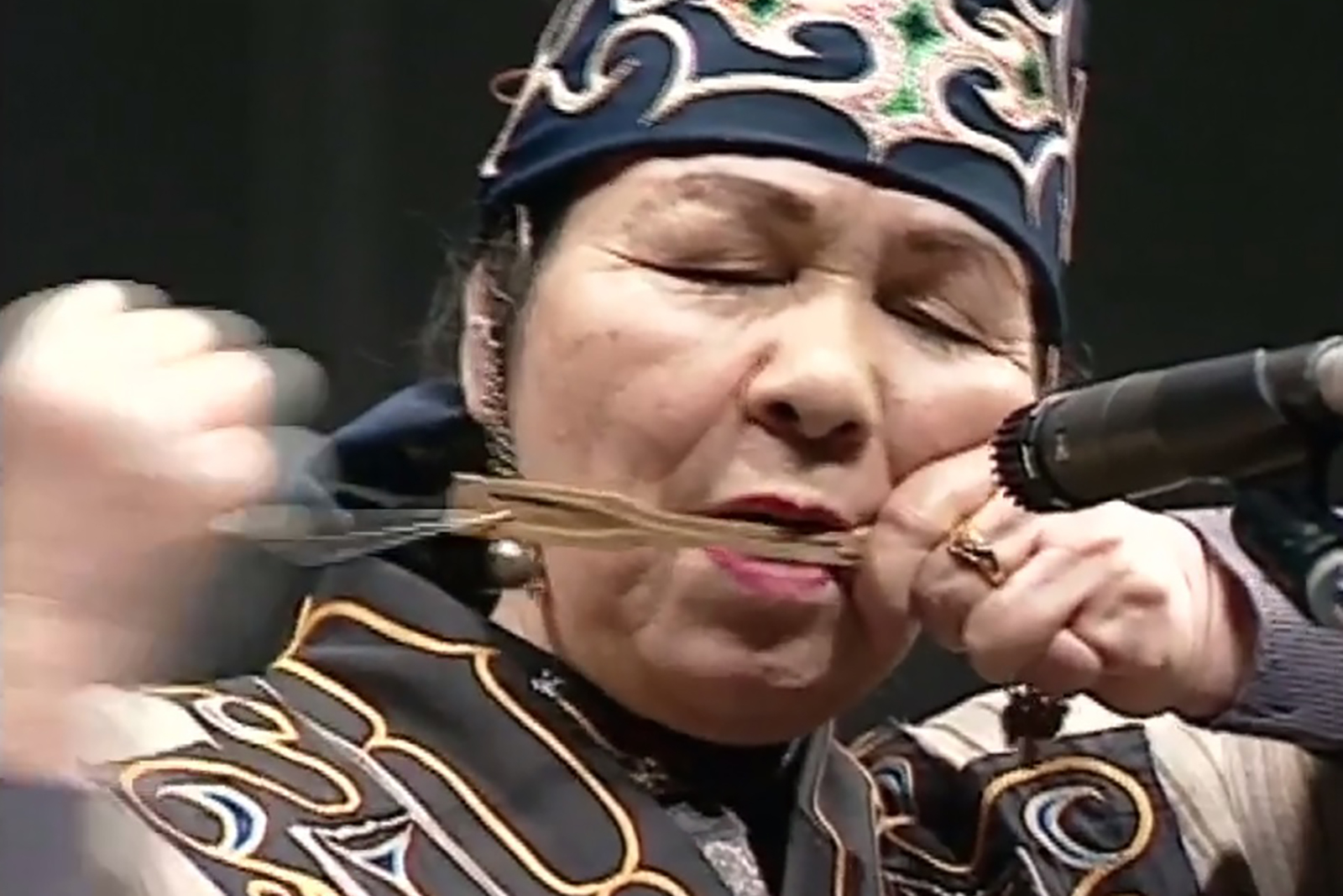 ムックリを演奏するアイヌ伝統衣装の女性